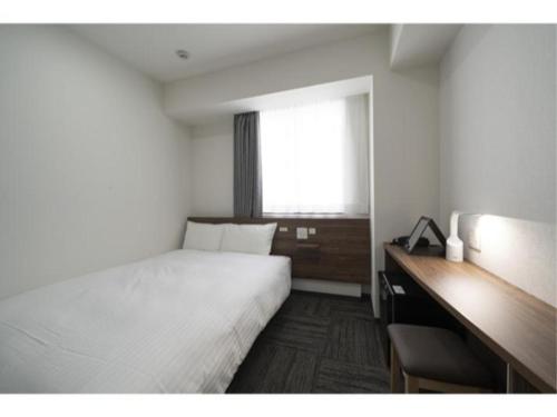 a bedroom with a bed and a desk and a window at R&B Hotel Nagoya Ekimae - Vacation STAY 15184v in Nagoya