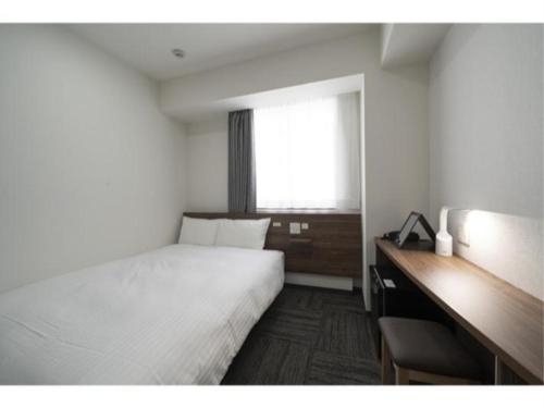 a bedroom with a bed and a desk and a window at R&B Hotel Nagoya Ekimae - Vacation STAY 15186v in Nagoya