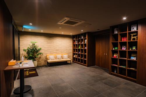 a waiting room with a couch and shelves of wine bottles at Randor Residential Hotel Kyoto Suites in Kyoto
