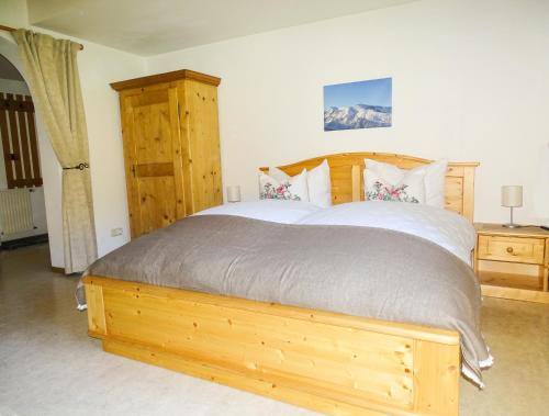 a bedroom with a large bed with a wooden frame at Haus Schneeberg mit Hochkönig Card in Mühlbach am Hochkönig