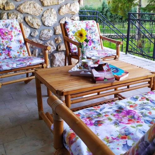 a wooden table and two chairs on a patio at Šumski Raj- Forest Paradise in Velika Remeta