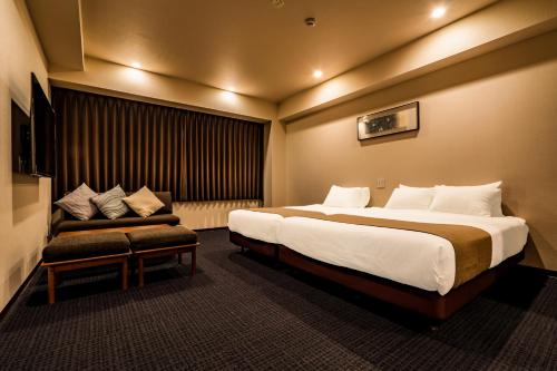 a hotel room with a large bed and a couch at Randor Residential Hotel Kyoto Suites in Kyoto