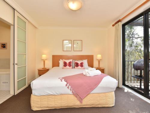 a bedroom with a bed and a large window at Villa 1br Champagne Villa located within Cypress Lakes Resort in Pokolbin