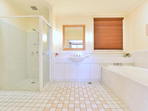 a bathroom with a tub and a sink and a shower at Villa Spa Executive 1br Champagne located within Cypress Lakes Resort in Pokolbin