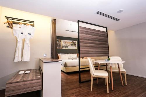 a hotel room with a bed and a table and chairs at Days Hotel & Suites by Wyndham KL - Chan Sow Lin MRT or LRT in Kuala Lumpur