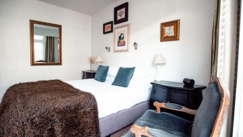 a bedroom with a bed and a chair and a mirror at The Duke Of Marlborough in Russell