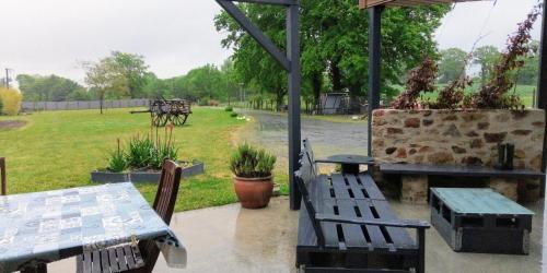 a patio with tables and benches and a horse drawn carriage at La chambre du Clos Barriant in Séreilhac