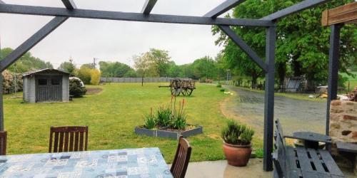 a patio with a table and a view of a yard at La chambre du Clos Barriant in Séreilhac