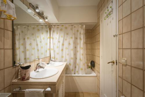 Un baño con lavabo y cortina de ducha. en Apartamento "El Lilà 3" - Parking incluido, en Platja d'Aro