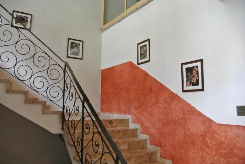 a staircase with orange and white walls and pictures on the wall at Appartement Gorgasser im Berghaus Glockner in Heiligenblut