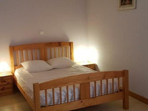 ein Schlafzimmer mit einem Holzbett mit zwei Nachttischen in der Unterkunft Gîte Villemontais, 4 pièces, 6 personnes - FR-1-496-121 in Villemontais