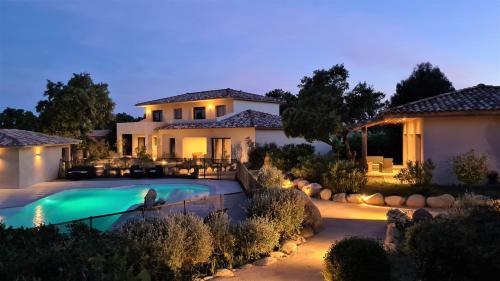 een huis met een zwembad in de nacht bij Villas Lantana in Porto-Vecchio