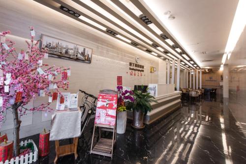 a hallway with flowers and plants in a building at Kending Kaying Hotel in Hengchun