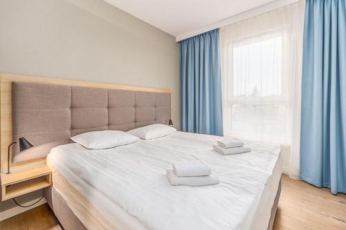1 dormitorio con 1 cama grande y 2 toallas. en Bel Mare 214B by Renters en Międzyzdroje