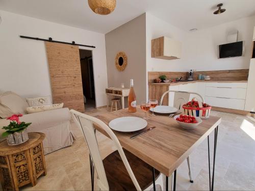 una cucina e una sala da pranzo con tavolo e sedie in legno di Cosy en Provence - Piscine chauffée de mai à septembre a Pernes-les-Fontaines