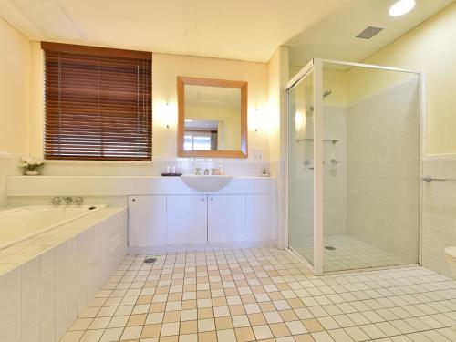a bathroom with a tub and a sink and a shower at Villa Spa Executive 1br Pinot located within Cypress Lakes Resort in Pokolbin