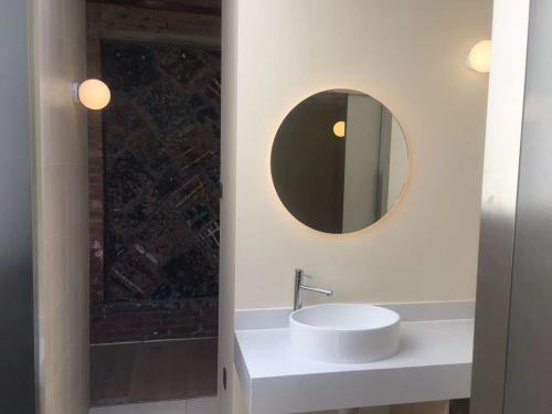 a bathroom with a white sink and a mirror at Brickyard Retreat at Mutianyu Great Wall Adjoin to Mutianyu Great Wall - Room with the View of Great Wall - Chinese massage experience - Vehicle Shuttle Service - International Catering - SPA& Nail Beauty Facilities in Huairou