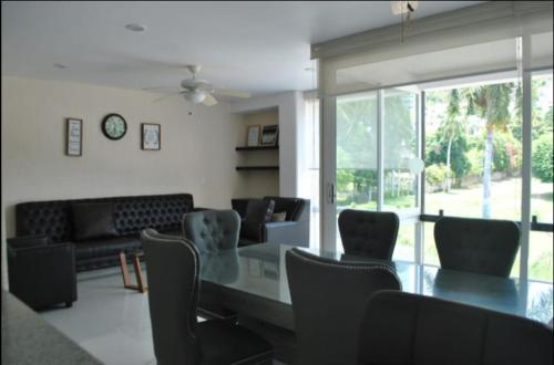 a dining room with a glass table and chairs at Suite Club Deportivo in Acapulco