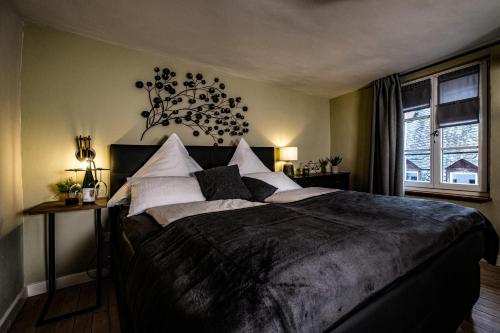 ein Schlafzimmer mit einem großen schwarzen Bett mit weißen Kissen in der Unterkunft ZaVélo Suite in Bernkastel-Kues