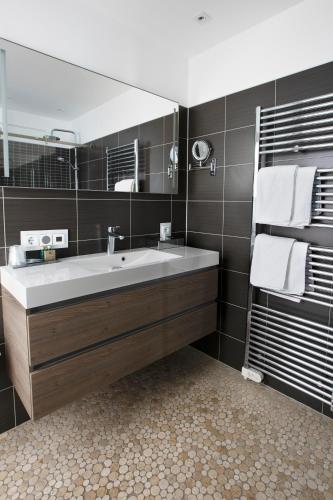 a bathroom with a sink and a large mirror at Apart! Food & Drinks Apartments in Zwolle