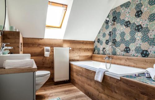 a bathroom with a tub and a toilet and a sink at Harmonia Apartman erkéllyel és SZAUNAval in Balatonfüred
