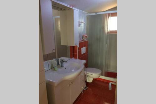 a bathroom with a sink and a toilet at just on the beach 'Zamalin' in Tribunj