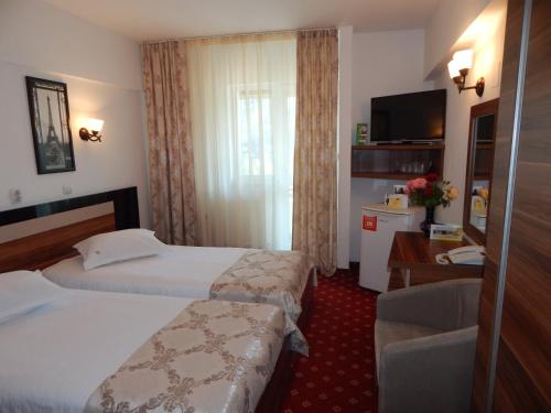 Postel nebo postele na pokoji v ubytování Hotel Traian Caciulata