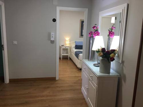 a bedroom with a bed and a dresser with flowers on it at Hostal Restaurante Alarico in Allariz
