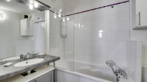 a white bathroom with a sink and a shower at DIFY Malot - Jean Macé in Lyon