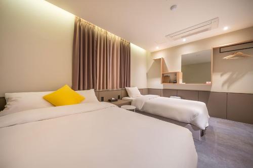 a hotel room with two beds and a mirror at Chuncheon Bom Stay in Chuncheon