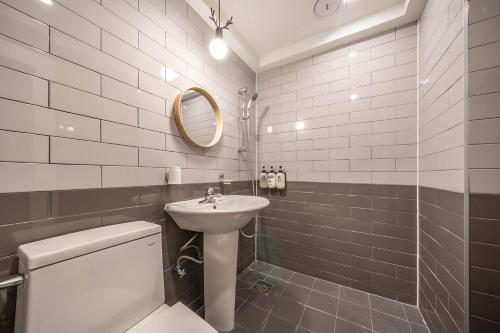a bathroom with a sink and a toilet and a mirror at Chuncheon Bom Stay in Chuncheon