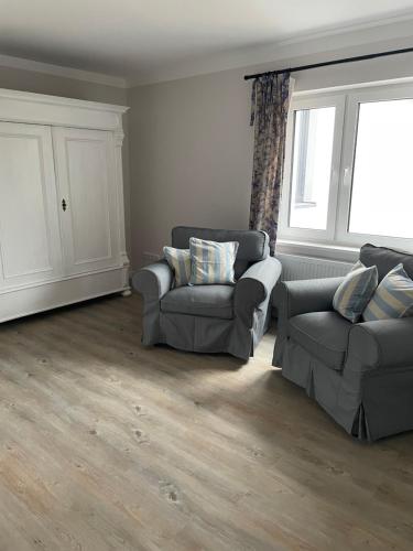 a living room with two couches and a window at Hotel & Ferienunterkünfte Hus Seeblick in Fehmarn