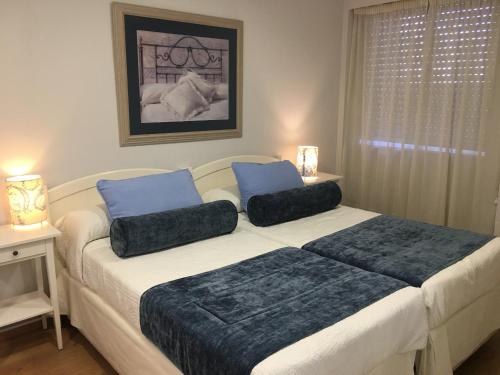a bedroom with a large bed with two pillows on it at Hostal Restaurante Alarico in Allariz