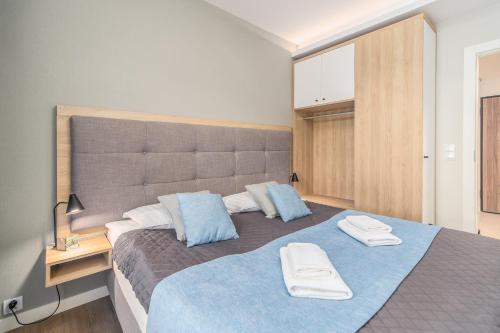 a bedroom with a large bed with two towels on it at Bel Mare Resort Apartment with Parking by Renters in Międzyzdroje