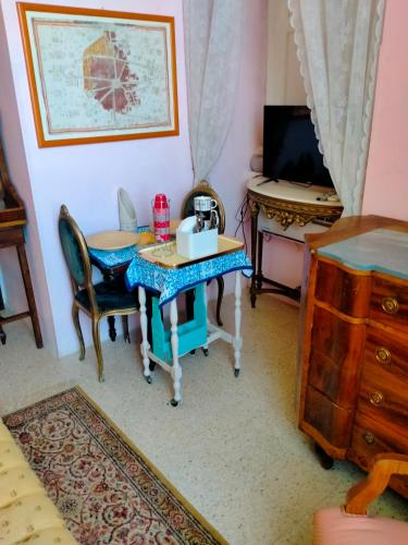 a room with a table and a desk with a television at Villa Longo de Bellis in Bari
