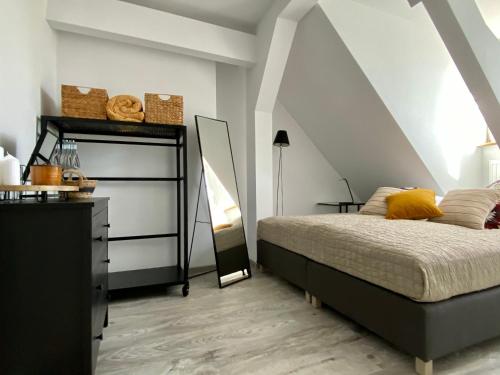 a bedroom with a bed and a dresser with a mirror at apartament Hrabala in Jelenia Góra