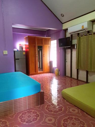 um quarto com paredes roxas e verdes e uma cozinha em บ้านสุขกมลแววดาวบ้านเดี่ยว1ห้องนอน em Ban Pak Nam