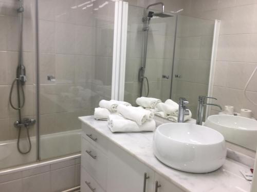 a white bathroom with a sink and a shower at Hostal Restaurante Alarico in Allariz