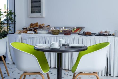 un tavolo e due sedie verdi in cucina di Faliraki Premium Hotel a Faliraki