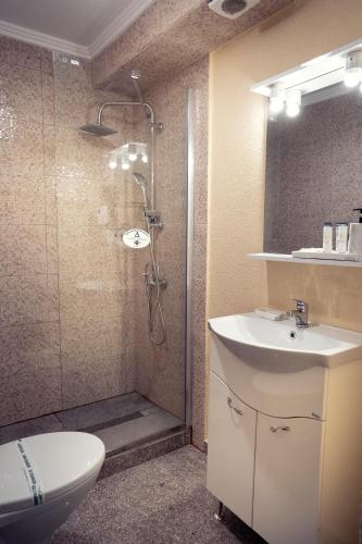 a bathroom with a shower and a sink and a toilet at London Apartments Vaslui in Vaslui