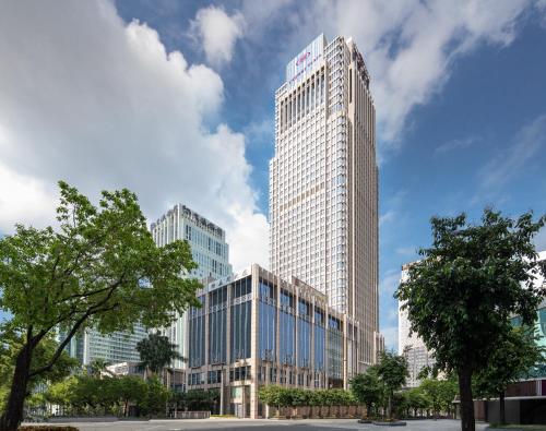 a tall building with a sign on top of it at Crowne Plaza Shenzhen Futian, Near to Shenzhen Convention&Exhibition Centre, Shenzhen Stock Exchange and Shenzhen Civic Center, Outdoor Heated Pool in Shenzhen