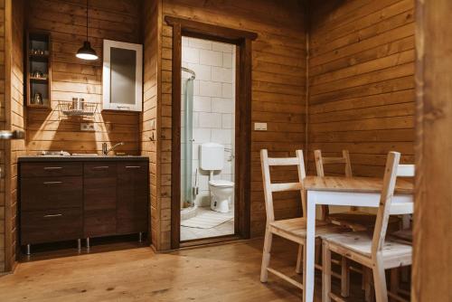 uma casa de banho com uma mesa, um lavatório e um WC. em MINARDI vendégházak em Berekfürdő