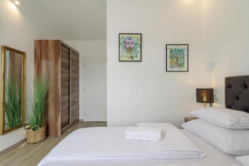 een witte slaapkamer met een bed en een bank bij Hotel Vila White in Trogir