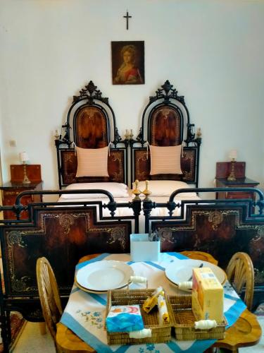 a dining room with two beds and a table with plates at Villa Longo de Bellis in Bari