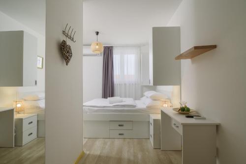 a white room with a bed and a window at Vila White in Trogir