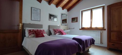 una camera con due letti e una finestra di Gavia Cottage a Ponte di Legno