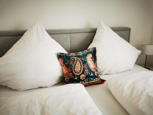 a bed with three pillows on it at Uferloft in Immenstaad am Bodensee