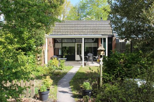 a small house with a garden and a fence at Vakantiehuis Veluwemeer House 40 in Biddinghuizen