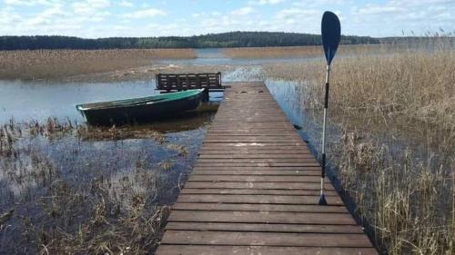 muelle de madera con un barco en un lago en Rosochate Wzgórze, en Krasnopol