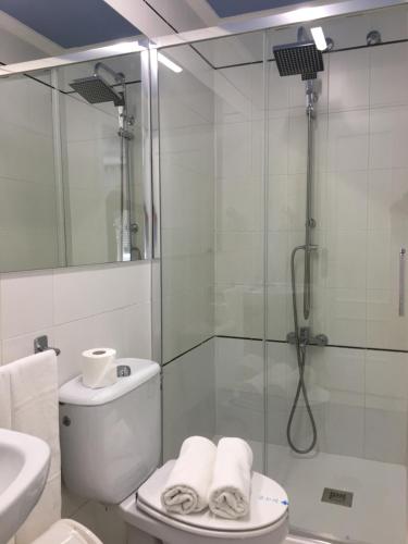 a bathroom with a shower and a toilet and a sink at Hostal Restaurante Alarico in Allariz